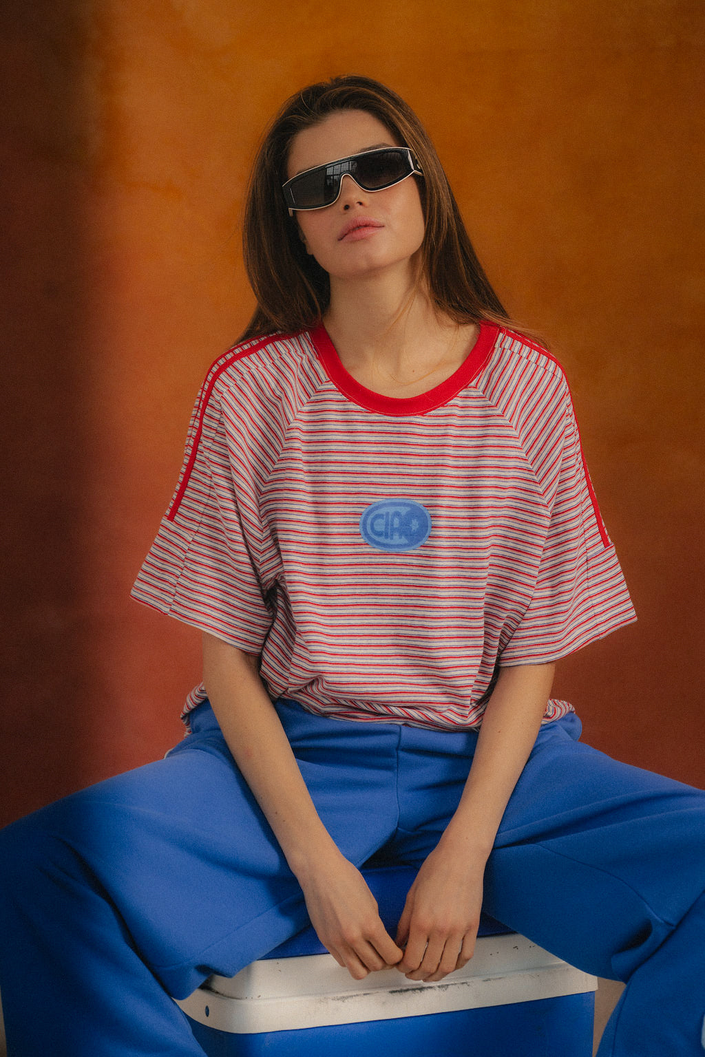 Ciao Ciao Vacation Rays Racer Tee - close-up of blue Ciao puff badge on stripe fabric