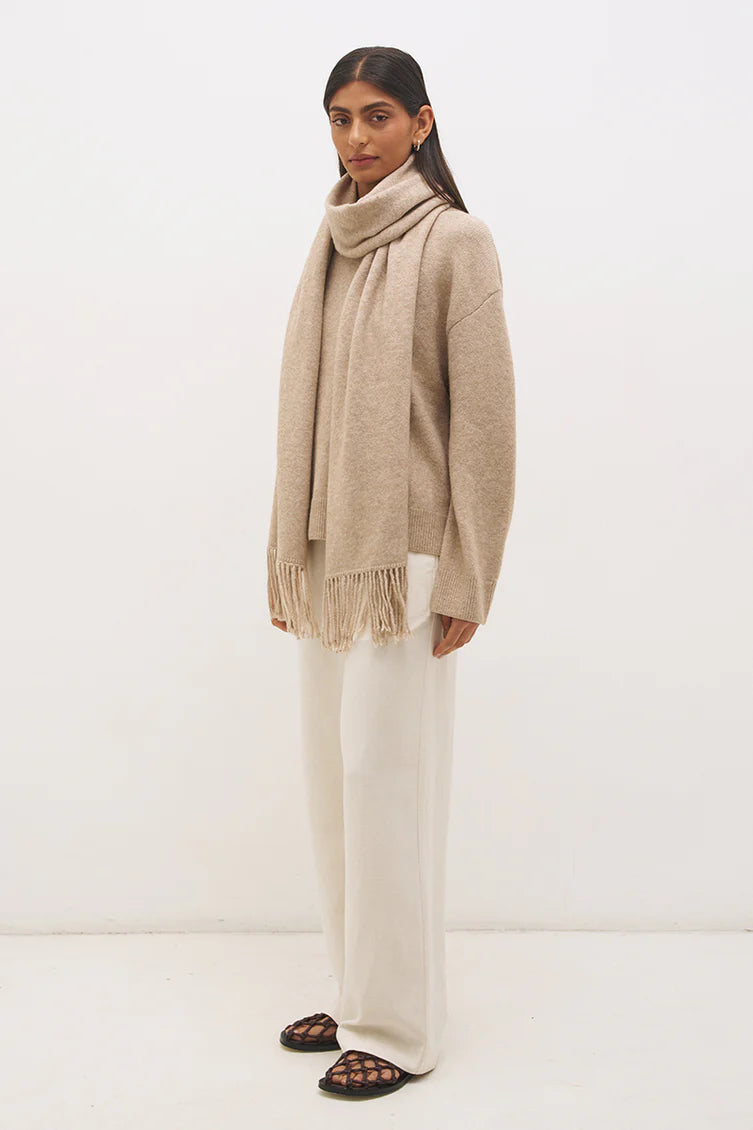 Mon Renn Scarf Knit Jumper in Natural — three-quarter side view with scarf draped, showing oversized dropped-shoulder silhouette in warm oat tone