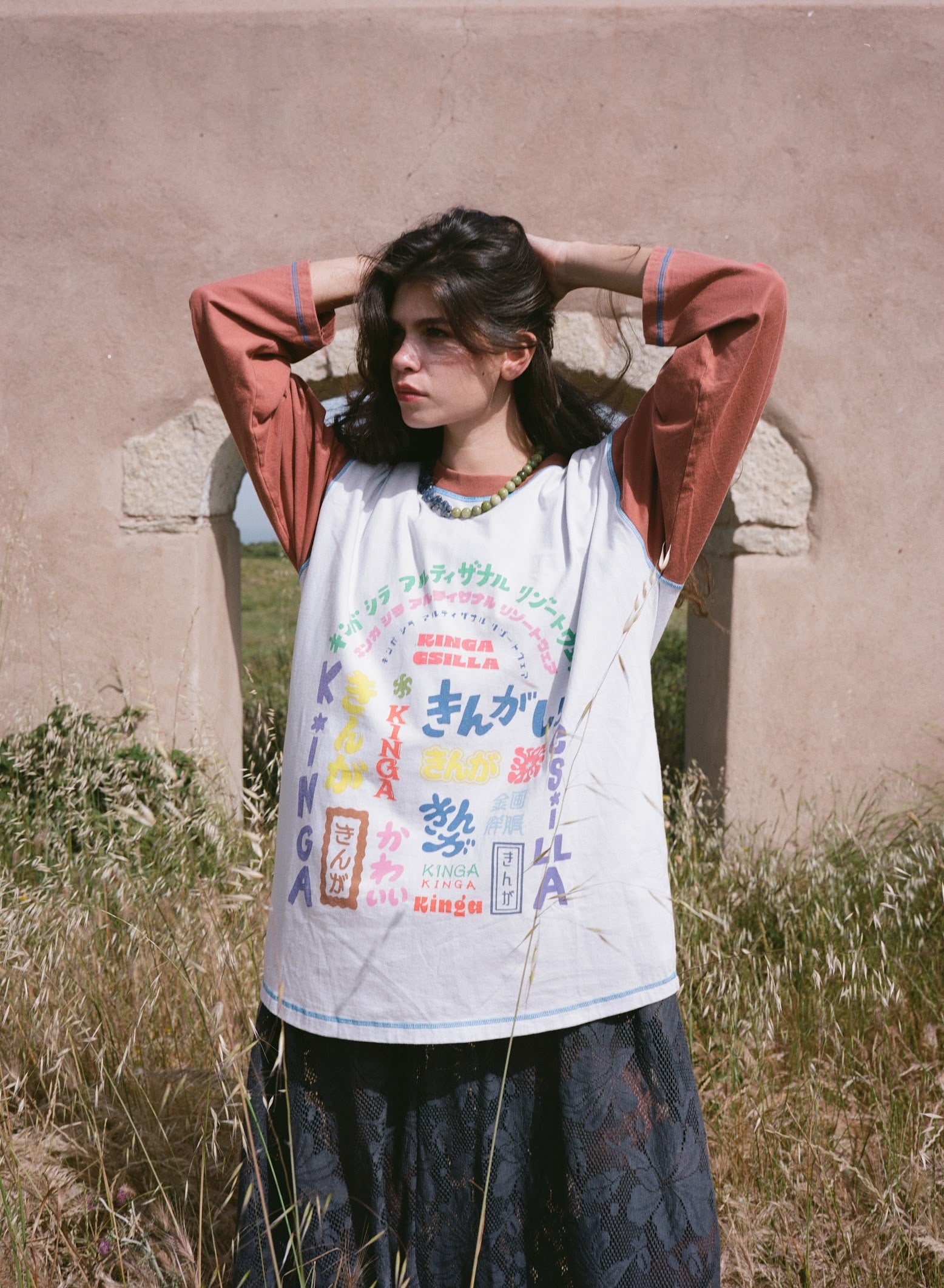 Kinga Csilla Japanese Sunset Tommy Tee in white — baseball raglan with rust terracotta 3/4 sleeves and hand-drawn Japanese-inspired graphic by Izumi Hooper