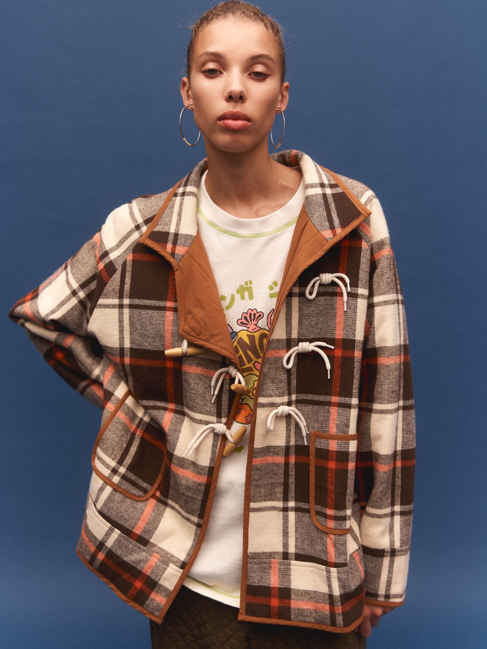 Kinga Csilla Rally Quilted Cocoon Jacket in tartan check — close-up of quilted construction and camel leather-look pocket trim